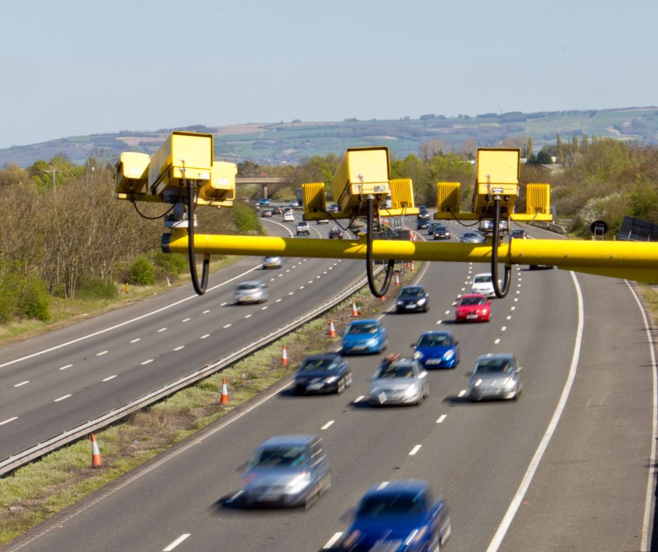 Average-speed camera on NSW highway monitoring light vehicles under 2025 road rule changes, with cars passing beneath.